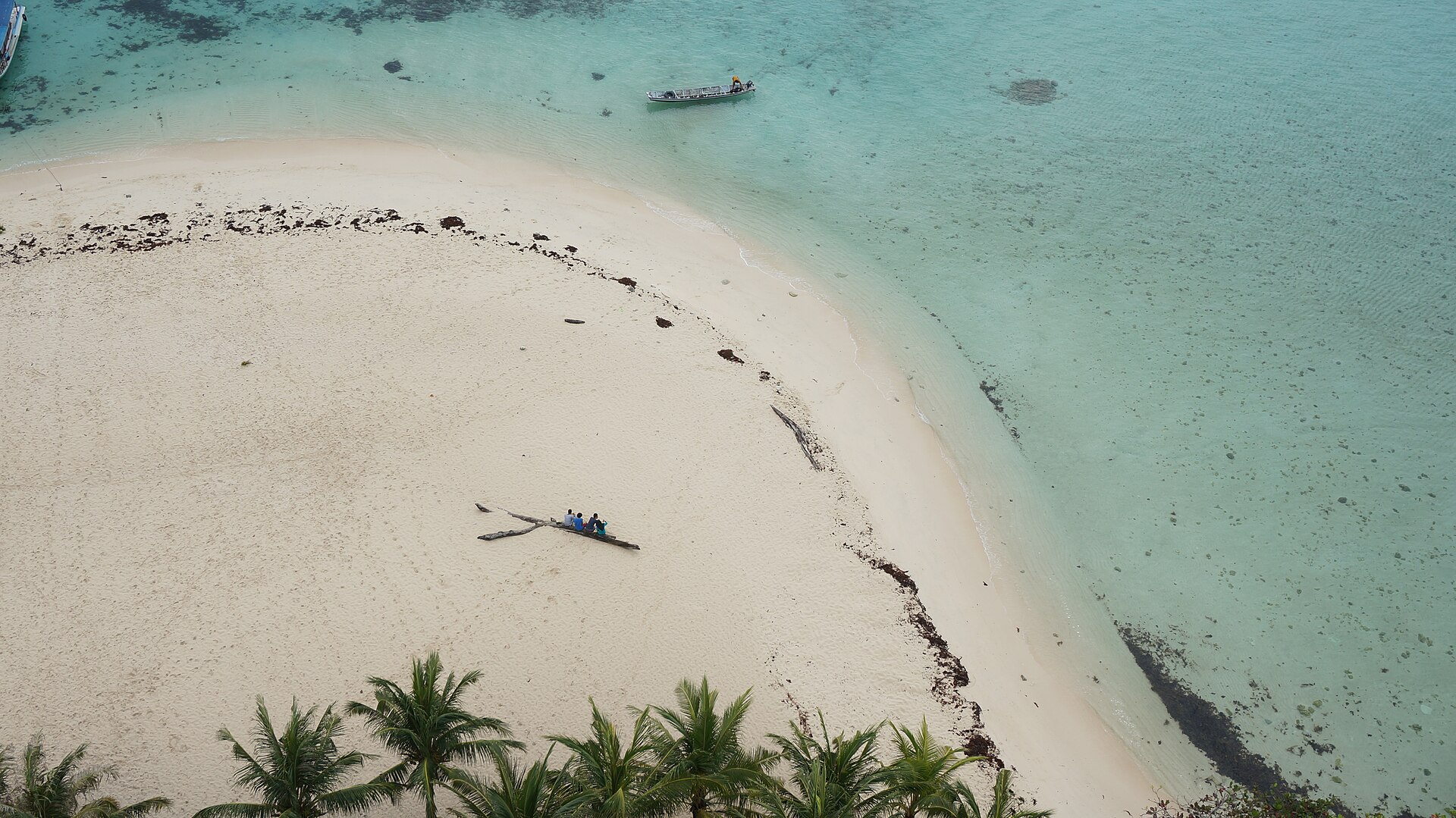 Boats beside the sandy shore of Lengkuas Island